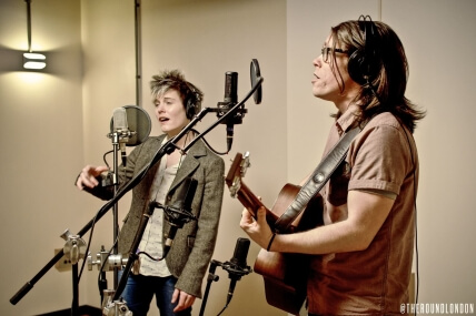 Two people playing guitar and singing